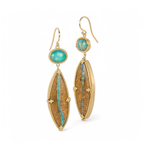 A pair of long, sand-colored earrings featuring opalized wood, suspended from small oval-shaped opals and set in 18k yellow gold.