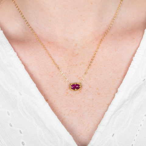 A model wears an 18k yellow gold and ruby gemstone necklace.