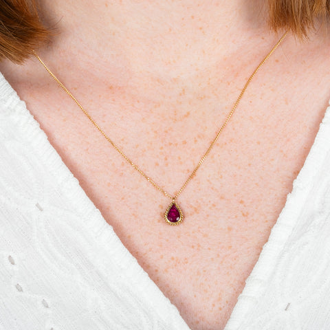 A model wears an 18k yellow gold and ruby gemstone necklace.
