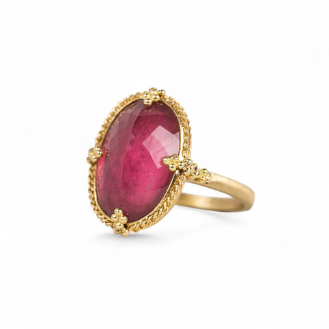 Side view of an 18k yellow gold and pink tourmaline oval ring.