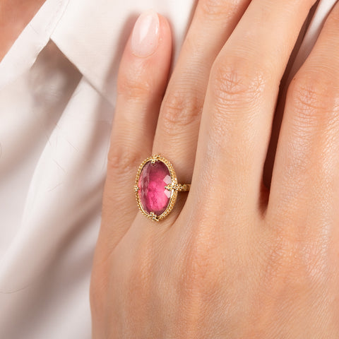 A model wears an 18k yellow gold and pink tourmaline oval ring.