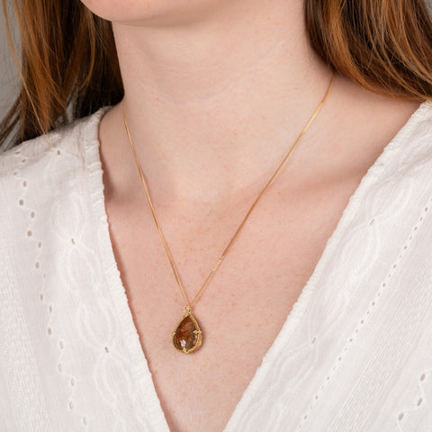 A model wears a teardrop shaped Spessartite and 18k gold necklace.