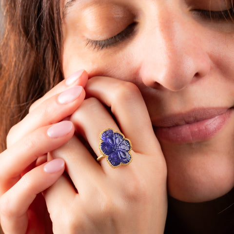 Carved tanzanite ring on a model 