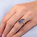 Carved tanzanite leaf ring worn on model