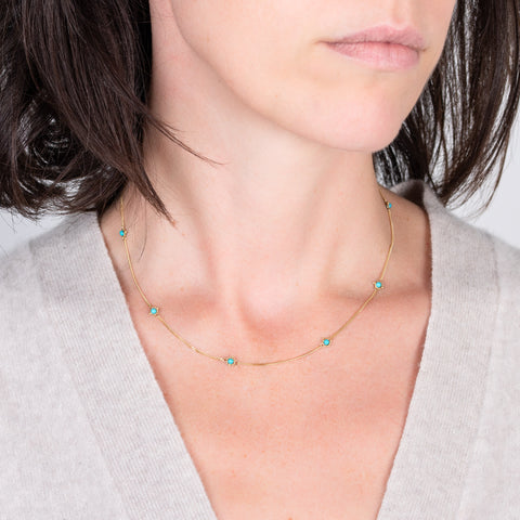 18k yellow gold chain necklace with turquoise gemstone beads worn on a model.