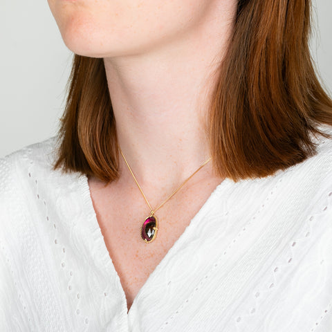 A model wears an 18k yellow gold and watermelon tourmaline gemstone necklace.