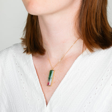 A model wears a watermelon tourmaline and 18k yellow gold necklace.