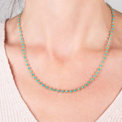 A model wears an 18k yellow gold and turquoise bead chain necklace.