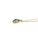 A side-view of a teardrop shaped aquamarine stone necklace set in 18k yellow gold.