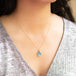 A model wears this teardrop Moonstone pendant on an 18K yellow gold chain. Handmade gold bezel features braided detail.