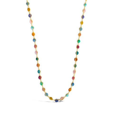 A multi-colored woven gemstone bead necklaces features multiple gemstones including Aquamarine, Opal, apatite, Moonstone, Tanzanite, Carnelian, Tourmaline, Amazonite, Rhodochrosite, Chalcedony and  Jade. The stones are set in a long 18k yellow gold chain.