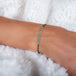 A close-up of an oxidized sterling silver bracelet that features a row of turquoise beads suspended in 18k yellow gold chain in the center.