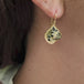 A video of a model wearing a leopard jasper earring featuring a leopard carving set in 18k gold.