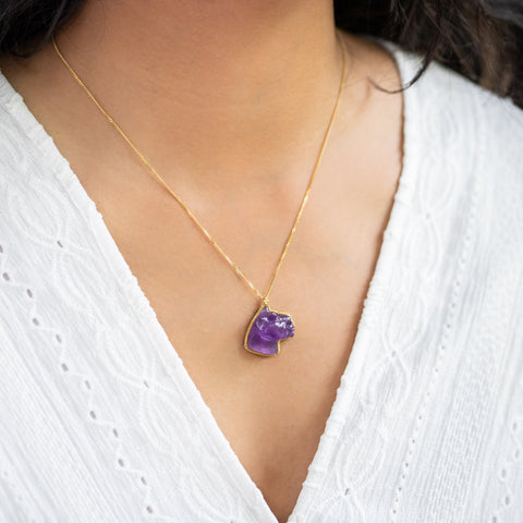 A model wears this Amethyst panther pendant on an 18K yellow gold chain. Handmade gold bezel features braided detail. Handmade in New York.