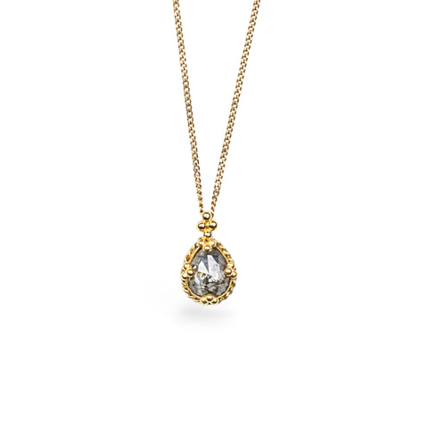 A Unique Diamond pendant in 18k yellow gold bezel, suspended from an 18K yellow gold chain. The diamond features dark grey flecks over silver. Handmade gold bezel, braided detail, and granulation. Chain with lobster clasp closure. Handmade in New York. 