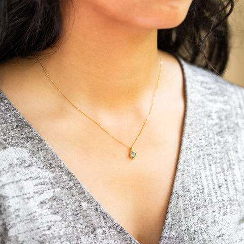 A Unique Diamond pendant in 18k yellow gold bezel, suspended from an 18K yellow gold chain. The diamond features dark grey flecks over silver. Handmade gold bezel, braided detail, and granulation. Chain with lobster clasp closure. Handmade in New York.
