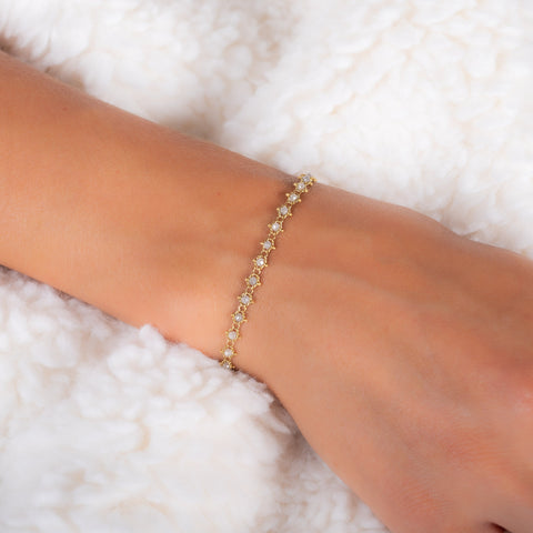 This 18k yellow gold bracelet features silver diamond beads woven throughout a delicate chain.