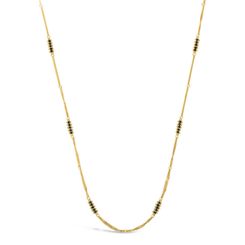 This 18k yellow gold chain necklace features rows of black diamond stations woven throughout the necklace. The piece is finished with a lobster clasp closure.