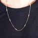 A model wears an 18k yellow gold chain necklace with rows of silver diamond stations woven throughout.
