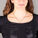 A model wears a small oval shaped Australian opal pendant set in an 18k yellow gold bezel on an oxidized sterling silver chain.