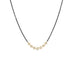 A row of small pearls is set in 18k yellow gold and are placed on an oxidized sterling silver chain.
