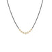 A row of small pearls is set in 18k yellow gold and are placed on an oxidized sterling silver chain.