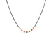 This short necklace is crafted with 18k yellow gold wrapped rubies in the center of an oxidized sterling silver chain.