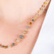Close up of a multi-colored diamond necklace featuring diamonds in colors such as grey, yellow, rust and charcoal that are strung in 18k yellow gold chain.