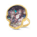 A large purple hued opal is carved into a skull and set in a braided 18k yellow gold bezel. The stone rests on a thin ring band.
