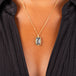 A vertical rectangular black diamond pendant is set in an 18k yellow gold chain wrapped bezel with four beaded prongs. The pendant is hanging on a delicate chain.