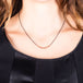 A model wears a short necklace with 18k yellow gold wrapped rubies set in the center of an oxidized sterling silver chain.