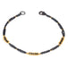 This oxidized sterling silver chain bracelet has three black diamond and 18k yellow gold bars stationed throughout.
