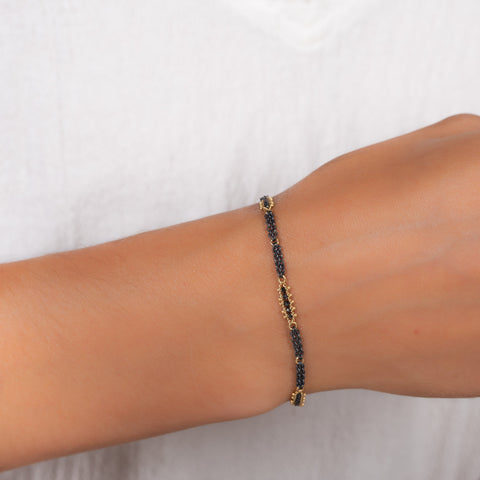 This oxidized sterling silver chain bracelet has three black diamond and 18k yellow gold bars stationed throughout.