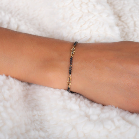 This oxidized sterling silver chain bracelet has three champagne diamond and 18k yellow gold bars stationed throughout.