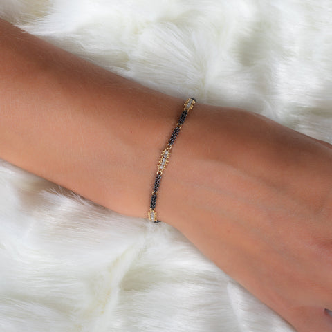 This oxidized sterling silver chain bracelet has three silver diamond and 18k yellow gold bars stationed throughout.