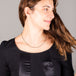 A model wears a short emerald station necklace with 18k yellow gold bezels and set throughout an oxidized sterling silver chain.