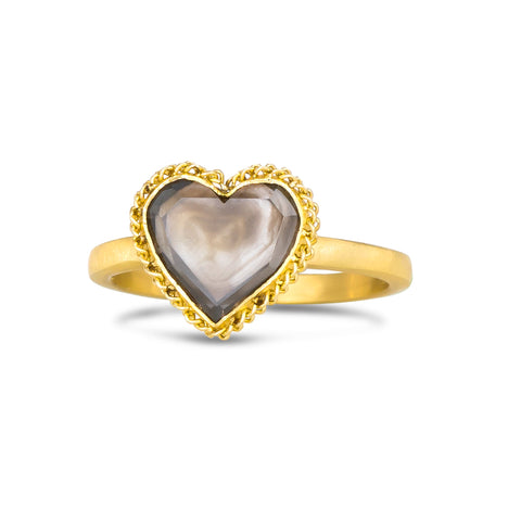 A heart shaped champagne colored diamond is set in an 18k yellow gold chain wrapped bezel. The ring is set on a thin band.