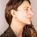 A model wears a medium 18k yellow gold diamond cut chain hoop earring that has a glittering stardust like effect.