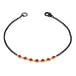 This oxidized sterling silver bracelet features a row of red rubies suspended in 18k yellow gold chain in the center.
