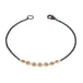 This oxidized sterling silver bracelet features a row of blue tanzanite suspended in 18k yellow gold chain in the center.