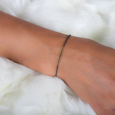 This oxidized sterling silver chain bracelet features a row of champagne diamonds suspended in 18k yellow gold chains.
