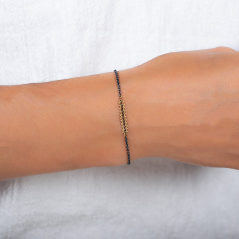 This oxidized sterling silver chain bracelet features a row of champagne diamonds suspended in 18k yellow gold chains.