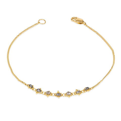 This delicate 18k yellow gold chain bracelet features a row of woven grey diamonds in the center and closes with a lobster clasp.