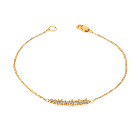 This delicate 18k yellow gold chain bracelet features a row of woven silver diamonds in the center and closes with a lobster clasp.