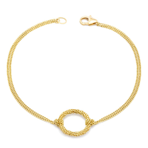 This delicate 18k yellow gold chain bracelet features a circle in the center with a stardust like effect.