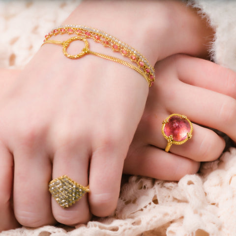This delicate 18k yellow gold chain bracelet features a circle in the center with a stardust like effect.