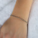 This 18k yellow gold bracelet features tanzanite beads woven throughout a delicate chain. The bracelet features a lobster clasp closure.