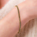 This delicate 18k yellow gold bracelet is delicately woven with blue diamond beads throughout. The bracelet is finished with an 18k yellow gold lobster clasp.
