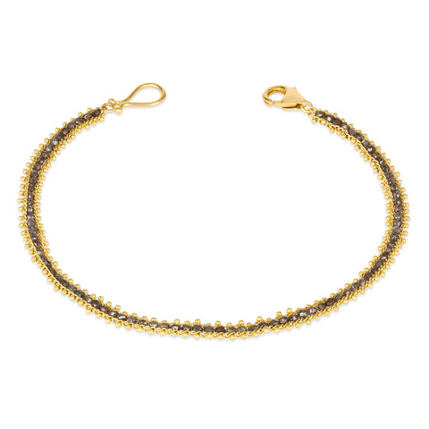 This delicate 18k yellow gold bracelet is delicately woven with champagne diamond beads throughout. The bracelet is finished with an 18k yellow gold lobster clasp.