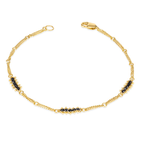 This 18k yellow gold chain bracelet features three black diamond bars stationed throughout. The bracelet is finished with a lobster clasp.